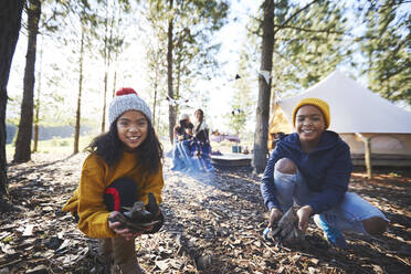 Porträt glückliche Bruder und Schwester spielen im Herbst Blätter auf sonnigen Campingplatz im Wald - CAIF23694