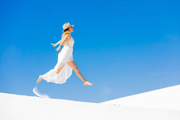 Frau springt auf der Gipssanddüne, White Sands, New Mexico, Vereinigte Staaten von Amerika, Nordamerika - RHPLF13110