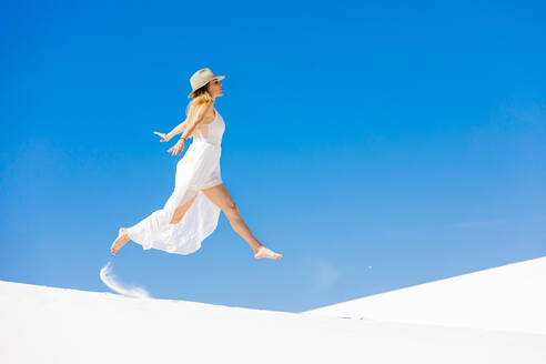 Frau springt auf der Gipssanddüne, White Sands, New Mexico, Vereinigte Staaten von Amerika, Nordamerika - RHPLF13110