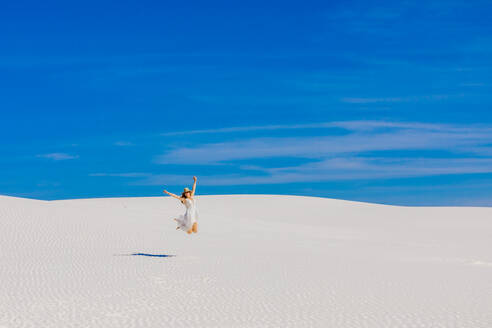 Frau springt auf Gipssanddüne, White Sands, New Mexico, Vereinigte Staaten von Amerika, Nordamerika - RHPLF13112