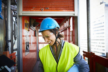 Lächelnde Ingenieurin in reflektierender Kleidung auf einer Baustelle - MASF15266