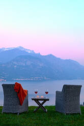 Sessel und Rotwein mit Blick auf den Comer See bei Sonnenuntergang, Lombardei, Italienische Seen, Italien, Europa - RHPLF13266