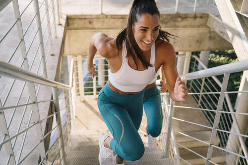 Zwei sportliche Zwillingsschwestern laufen eine Treppe hinauf - JCMF00325