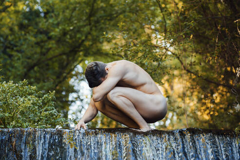 Nackter junger Mann an einem Wasserfall - MIMFF00039