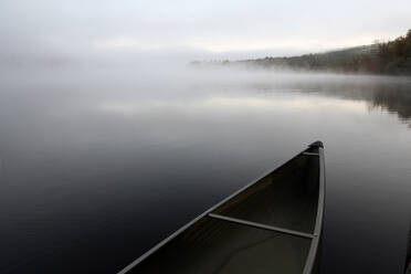 Ein schnittiges Kanu, das an einem Steg auf einem ruhigen Teich in Maine festgemacht ist. - CAVF70488