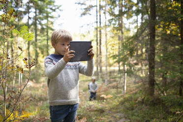 Junge fotografiert den Wald, sein Bruder folgt ihm - CUF53712