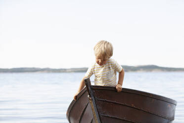 Junge spielt in einem Boot am Strand - CUF53742