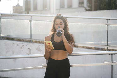 Junge Frau benutzt Smartphone im Stadtpark - CUF53761