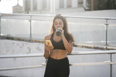 Young woman using smartphone in city park - CUF53761