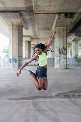 Woman jumping in mid air in city - CUF53869