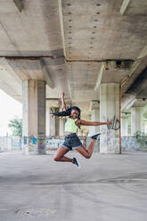 Woman jumping in mid air in city - CUF53870