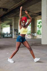 Woman dancing under bridge in city - CUF53873