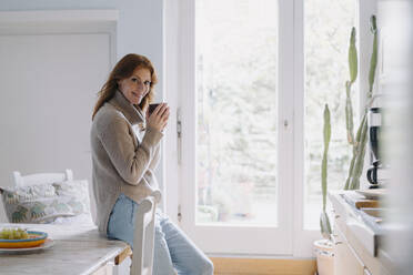 Woman drinking coffee in kitchen - JOSF04060