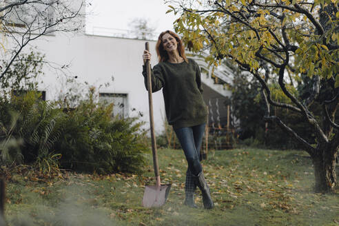 Woman working in her garden, holding shovel - JOSF04076