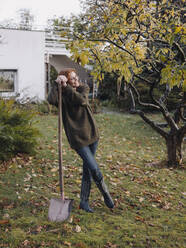 Frau bei der Arbeit im Garten, mit Schaufel in der Hand - JOSF04105
