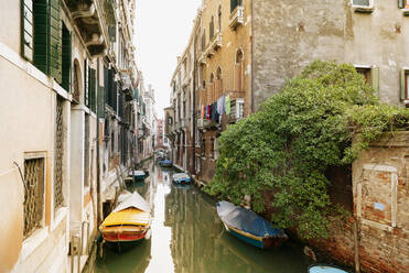 Boat moored on canal amidst buildings in city - CAVF70620