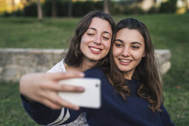 Schwestern nehmen Selfie im Park - CUF53911