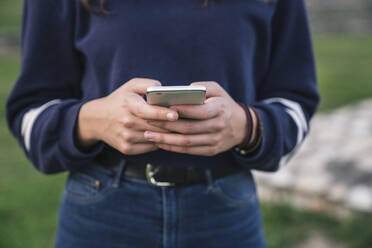 Frau benutzt Smartphone im Park - CUF53913