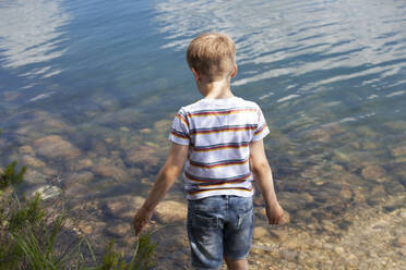 Boy playing near lake - CUF53972