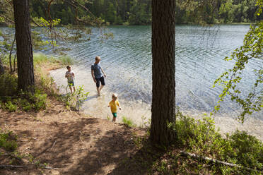 Vater und Söhne spielen am See, Finnland - CUF53984