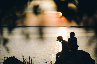 Two boys sitting on rock - JOHF04942