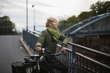 Ältere Frau ruht sich während einer Fahrradtour aus - JOHF04962