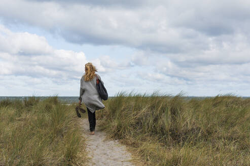 Woman walking towards sea - JOHF04966