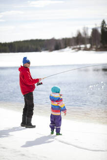 Vater mit Kind beim Fischen im Winter - JOHF04983
