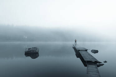 Mann auf Pier im See im Morgennebel - JOHF05024