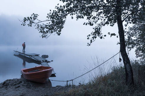 Mann auf Pier im See im Morgennebel - JOHF05025