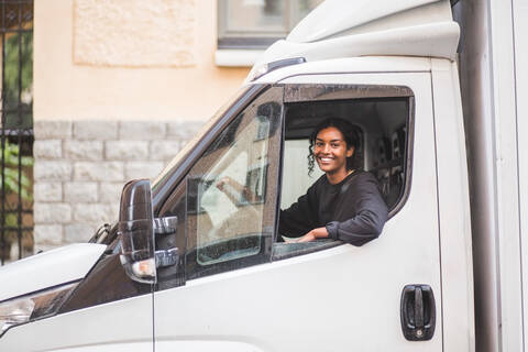 Porträt einer lächelnden Frau, die einen Lastwagen fährt, lizenzfreies Stockfoto