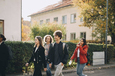 Teenager-Freunde gehen zusammen auf der Straße in der Stadt an einem sonnigen Tag - MASF15386