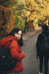 Portrait of teenage girl walking on road during autumn - MASF15387