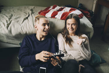 Porträt eines Teenagers und eines Mädchens, die ein Tonmischpult benutzen, während sie im Schlafzimmer Musik hören - MASF15430