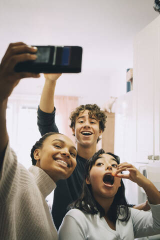 Fröhliche Freunde machen ein Selfie beim Essen zu Hause, lizenzfreies Stockfoto