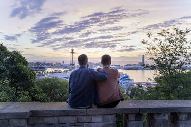Schwules Paar auf Aussichtspunkt über der Stadt mit Blick auf den Hafen, Barcelona, Spanien - AFVF04417