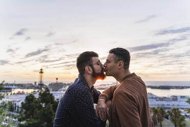 Schwules Paar küsst sich auf einem Aussichtspunkt über der Stadt mit Blick auf den Hafen, Barcelona, Spanien - AFVF04428