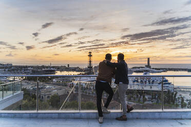 Schwules Paar auf Aussichtspunkt über der Stadt mit Blick auf den Hafen, Barcelona, Spanien - AFVF04429