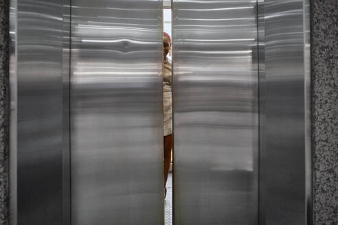Doors closing of an elevator with a young woman inside - VEGF01114