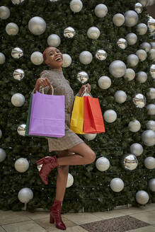 Woman with colorful shopping bags on a Christmas tree - VEGF01144