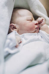 Portrait of baby boy lying on a bed - LJF01131