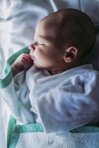 Porträt eines kleinen Jungen auf einem Bett liegend, lizenzfreies Stockfoto