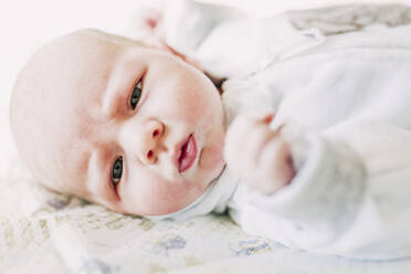 Portrait of baby boy lying on a bed - LJF01133