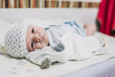 Porträt eines kleinen Jungen auf einem Bett liegend - LJF01134