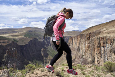 Frau beim Wandern auf dem Gipfel eines Hügels an den Maletsunyane-Wasserfällen, Lesotho - VEGF01166