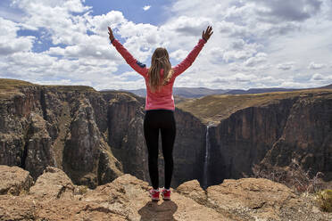 Frau steht auf einer Anhöhe an den Maletsunyane-Wasserfällen und genießt die Aussicht, Lesotho - VEGF01170