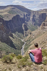 Man sitting on top of a hill at Maletsunyane Falls enjoying the view, Lesotho - VEGF01171