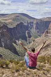 Man sitting on top of a hill at Maletsunyane Falls enjoying the view, Lesotho - VEGF01172