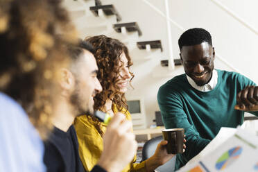 Lächelnde Kollegen bei einer Besprechung im Büro - FMOF00824