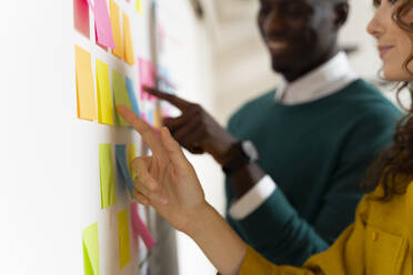 Two colleagues working together on post its in office - FMOF00826